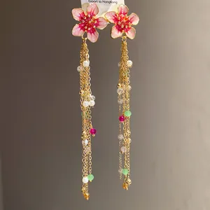 Vue détaillée de boucles d'oreilles fleurs roses vintage avec chaînes dorées