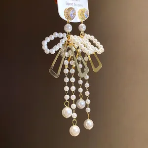 Elegant detail of French retro pearl bow tassel earrings with sparkling rhinestone studs