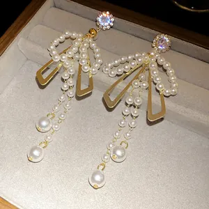 Close-up of elegant French vintage pearl bow tassel earrings displayed in a jewelry box