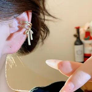 Close-up of a stylish gold bow ear cuff for non-pierced ears in a festive holiday setting