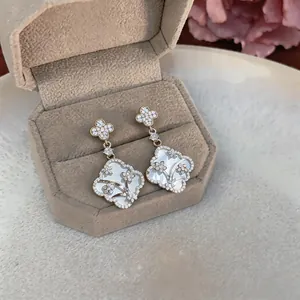 Detailed close-up view of clover flower earrings with mother-of-pearl and zirconia