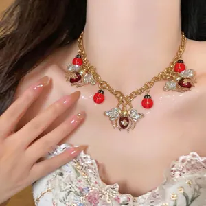 Elegant vintage gold chain necklace featuring enamel ladybugs and crystal bee pendants on a model