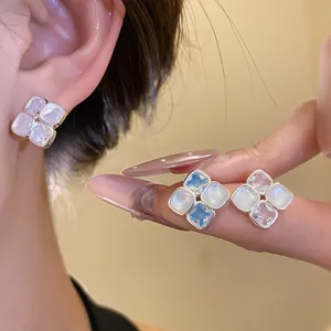 Close-up view of elegant rhombus zircon and resin stud earrings in multiple colors