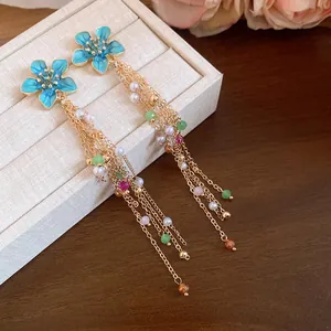 Vue détaillée de boucles d'oreilles vintage à fleurs bleues avec perles colorées
