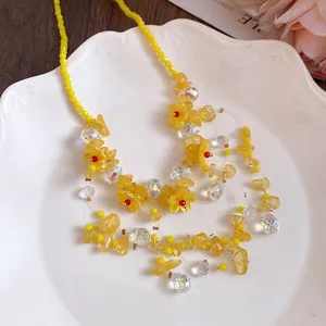 Dettaglio ravvicinato della collana di fiori in resina gialla con nappe di cristallo
