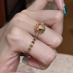 Dettaglio ravvicinato di anello a fiore placcato oro 18k con zirconi colorati e smalto
