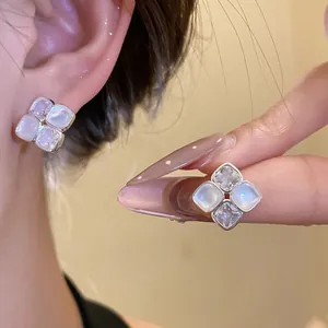 Close-up detail of vintage style square zircon and moonstone resin stud earrings on ear