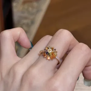 Primo piano di un anello a fiore in zircone colorato su un dito