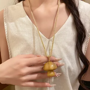 Detailed view of hand-woven cotton rope necklace with wooden mushroom pendant