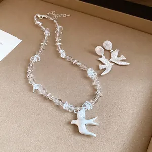 Detailed view of crystal bead necklace and elegant matte swallow pendant earrings set