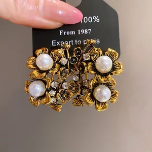 Vintage gold-tone flower stud earrings with elegant pearls and sparkling rhinestones
