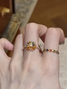 Vista dettagliata di una mano con un anello a fiore colorato e una fascia arcobaleno