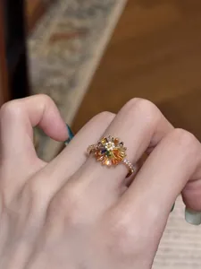 Primo piano di un elegante anello a forma di fiore in zirconia colorata placcato oro 18k