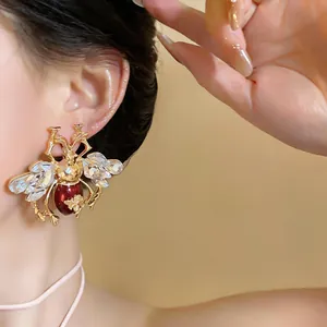 Close-up of a vintage crystal bee earring worn by a model, showing gold-tone details