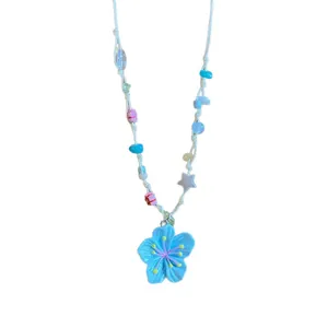 Summer beach style beaded necklace with a vibrant blue flower pendant and colorful beads