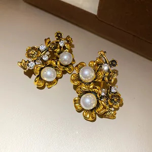Macro detail of vintage style flower stud earrings featuring pearls and rhinestones