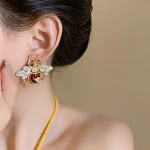 Detailed close-up view of vintage-style crystal beetle stud earrings worn on ear