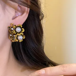 Close-up detail of vintage floral stud earrings with white pearls and sparkling crystals.