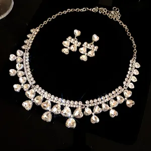 Close-up of elegant rhinestone heart pendant necklace and earrings set with sparkle effect