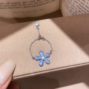 Close-up of vintage silver chain ring with blue zircon flower and adjustable bead.