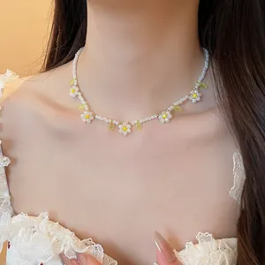 Dettaglio ravvicinato di una dolce collana di perline a margherita su una modella.