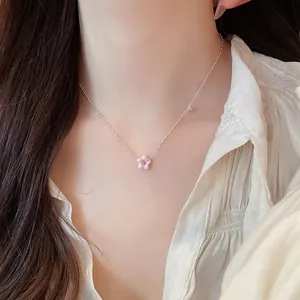Detailed close-up showing a pink flower lucky pendant necklace with zircon on a model's neck