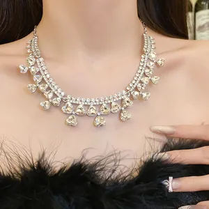 Detailed view of an elegant heart pendant necklace with rhinestones worn by a model