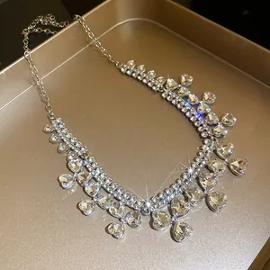 Macro detail of elegant silver-tone necklace featuring pavé rhinestones and heart charms