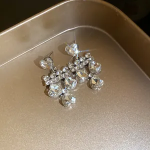 Close-up of heart-shaped rhinestone drop earrings with sparkling crystal accents