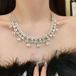 Elegant macro view of sparkling heart and drop rhinestone necklace worn by a fashion model
