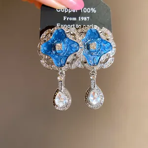 Detailed view of elegant blue enamel drop earrings with sparkling teardrop crystals
