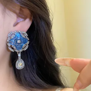 Detailed macro view of vintage palace style earrings with blue enamel and crystal teardrop