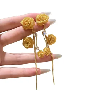 Boucles d'oreilles élégantes en maille dorée avec fleurs et pompons