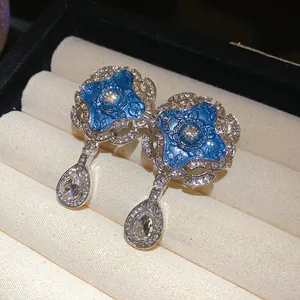Close-up of vintage blue enamel flower earrings with waterdrop crystal pendants