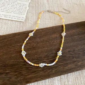 Dettaglio ravvicinato di una collana di perline colorate a fiori su base in legno