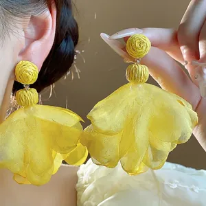 Yellow Bohemian chiffon flower tassel stud earrings presented on an Asian model