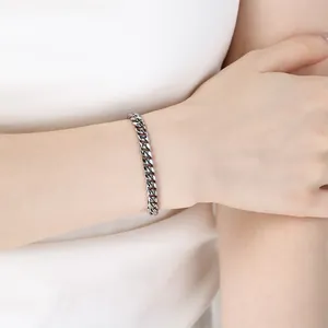 Bracciale a catena cubana lucido color argento mostrato sul polso di una modella