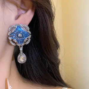 Close-up of vintage court style blue enamel earrings with rhinestone teardrop pendants