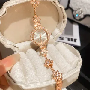 Detail macro shot of an elegant vintage gold floral bracelet watch with shiny rhinestones