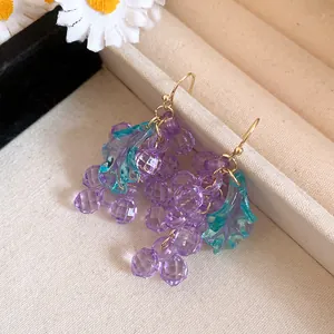 Detailed view of elegant purple acrylic grape drop earrings with translucent teal leaves