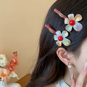 Detailansicht bunter Farbverlauf Blumen Haarspangen mit roten Perlen im Haar