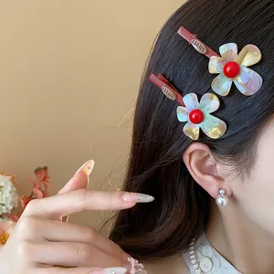 Detailaufnahme von süßen schillernden Blumen-Haarspangen im seitlichen Frauenhaar