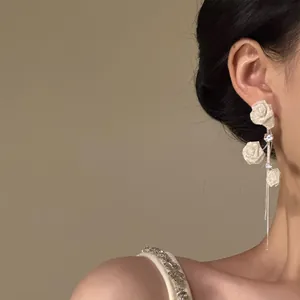 Gros plan de boucles d'oreilles élégantes en forme de rose blanche avec zircons