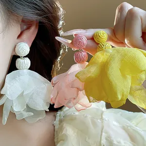 Detailed macro view of elegant bohemian chiffon flower tassel earrings in multi-colors.