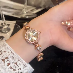 Close-up detail of a vintage rose gold lady's watch with rhinestone flower bracelet design