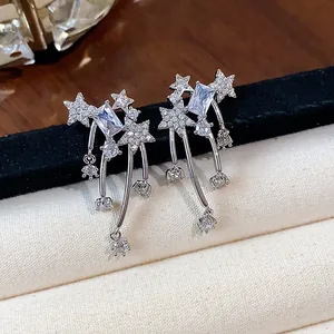 Dettaglio ravvicinato di orecchini a stella color argento con zirconi scintillanti.