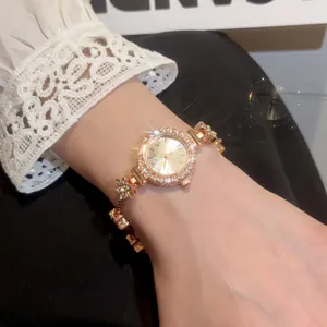 Close-up of a vintage gold-tone watch with sparkling rhinestones and flower chain