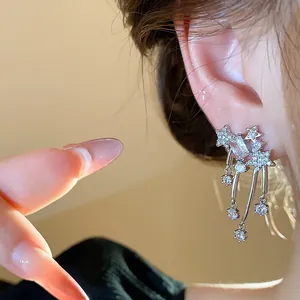Eleganti orecchini a stella in argento con zirconi lucenti indossati da una modella