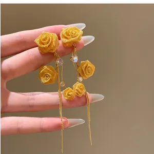 Elegant gold rose earrings with long chain tassels and zircon details for a luxury look.