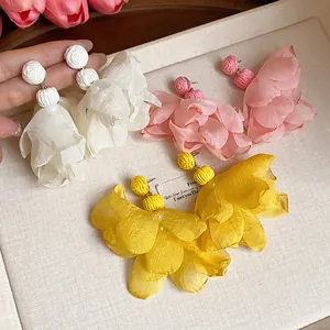 Detailed view of bohemian chiffon flower earrings in white pink and yellow colors